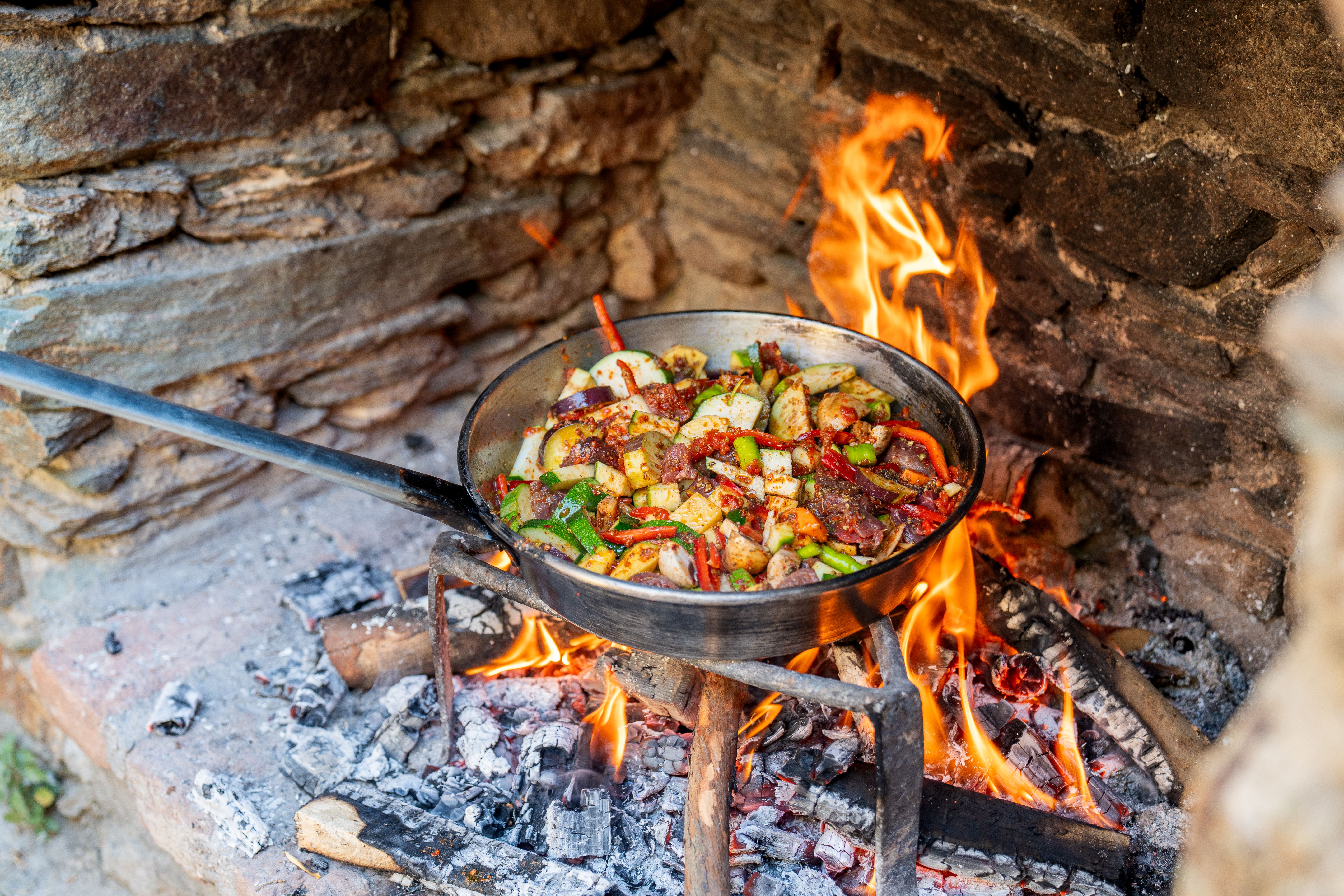 Colourful food cooking over open fire