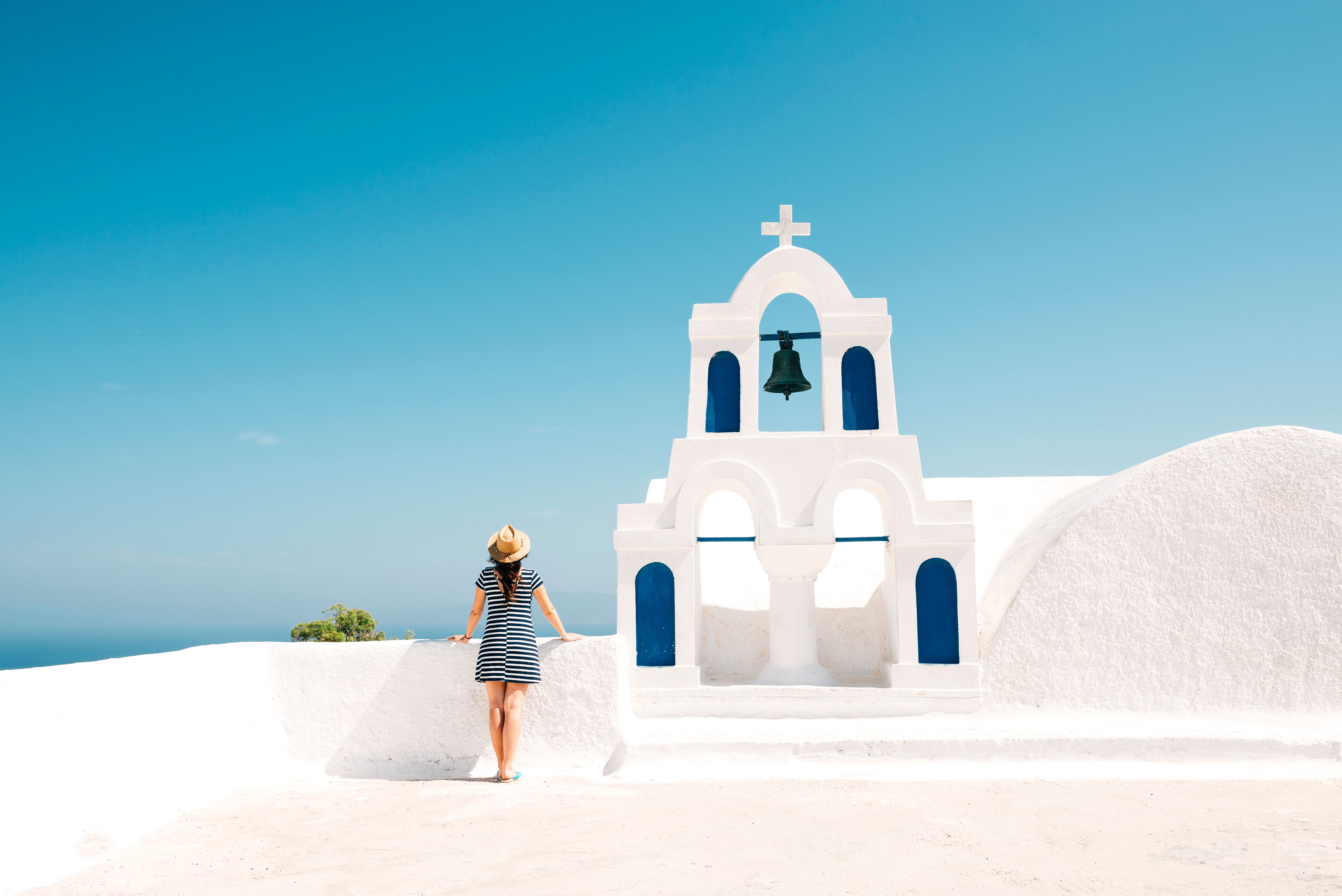 Greece, Santorini, Oia, woman standing next to bell tower