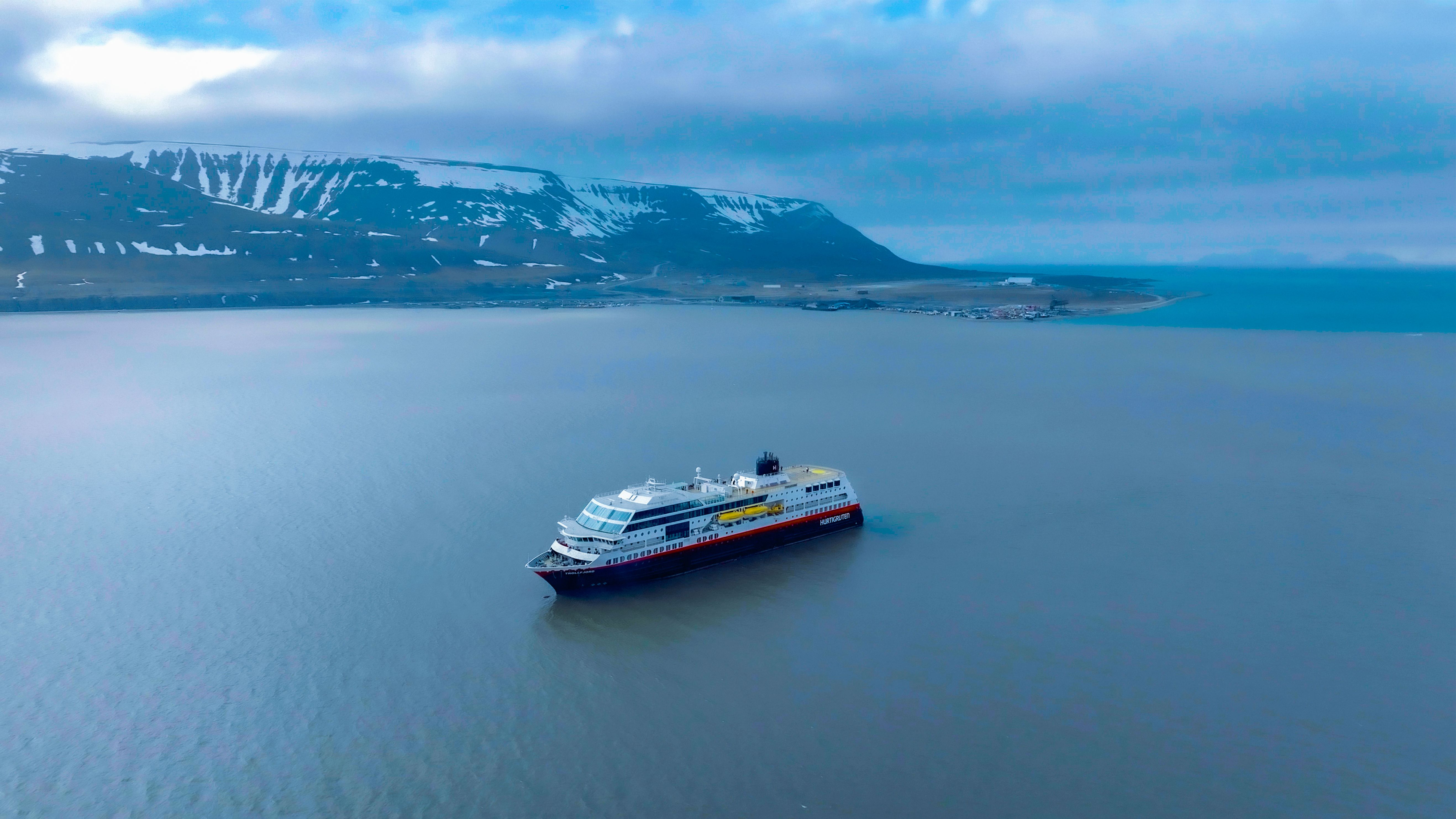 Hurtigruten Cruise along Norwegian coast with white-capped mountains behind
