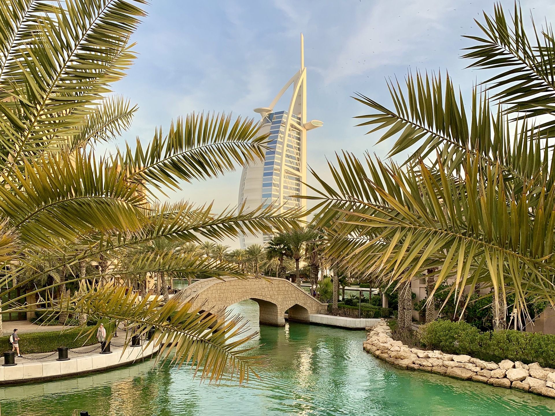 Palm trees and building over river in Dubai.